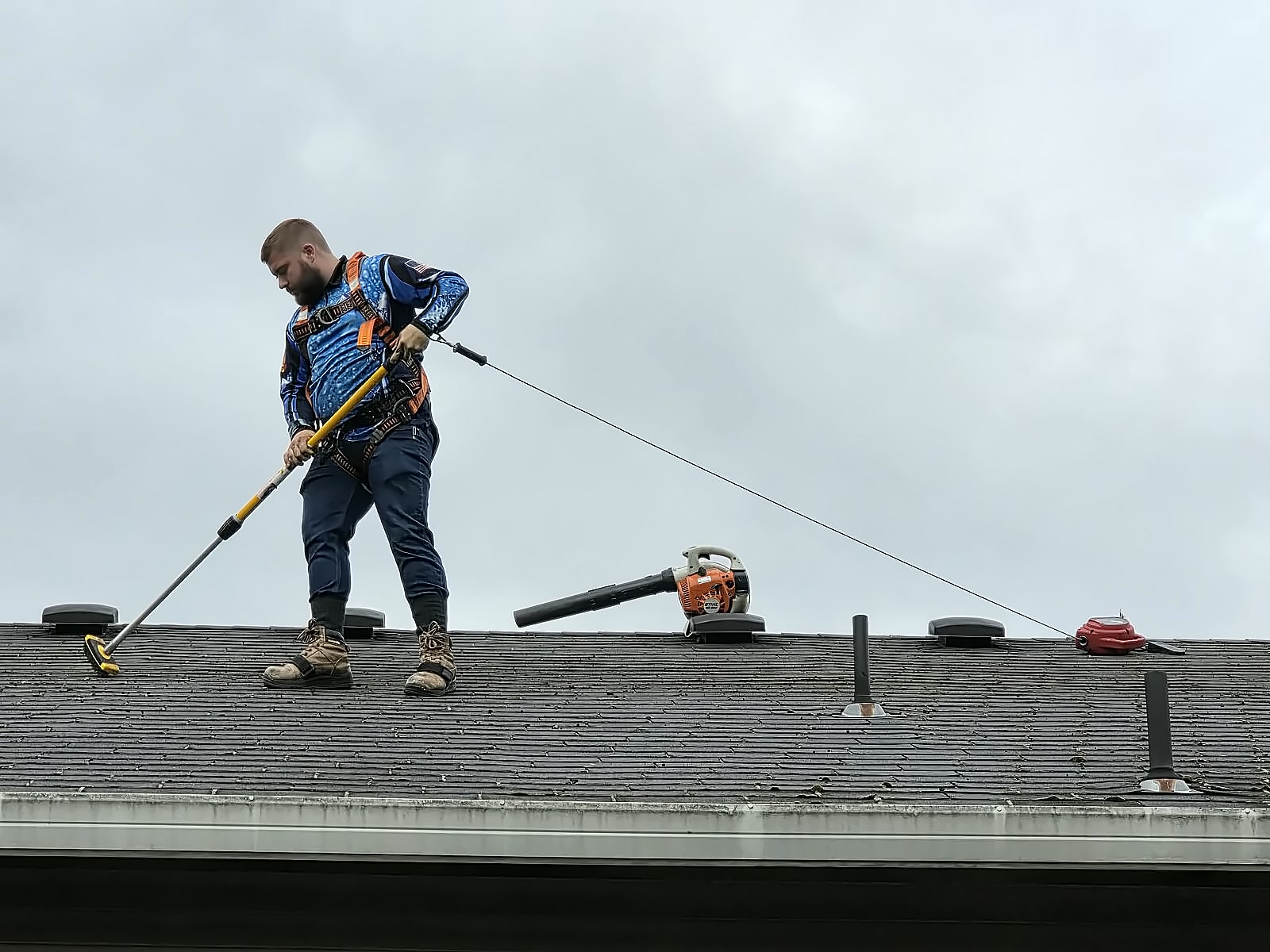 Dakota cleaning moss off a roof in Vancouver, WA