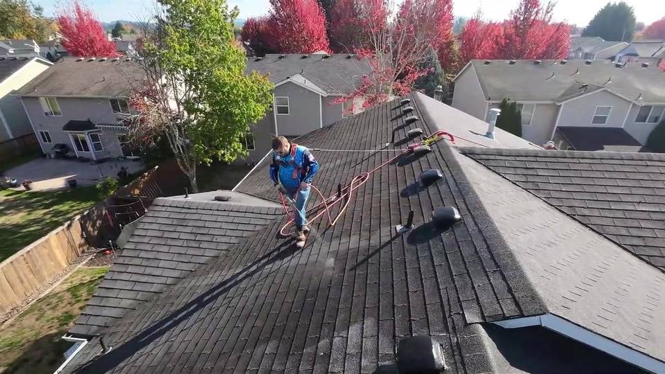 Drone view of a roof being soft washed